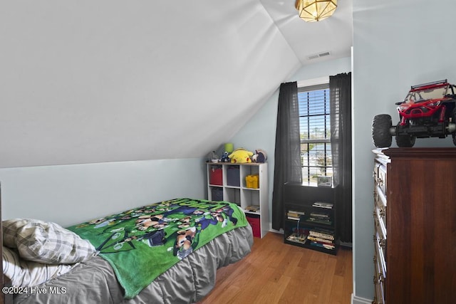 bedroom featuring light hardwood / wood-style flooring and lofted ceiling