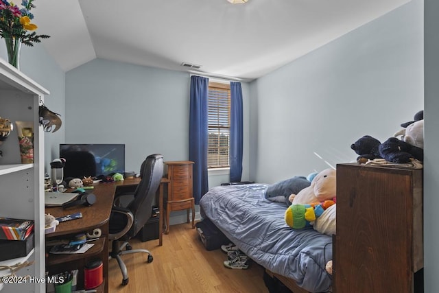 bedroom with light hardwood / wood-style floors and lofted ceiling