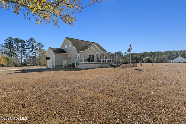 back of property with a deck and a sunroom