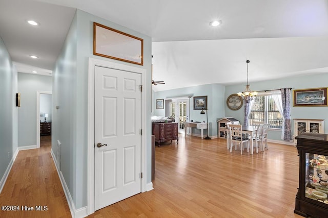 corridor featuring light hardwood / wood-style floors and an inviting chandelier