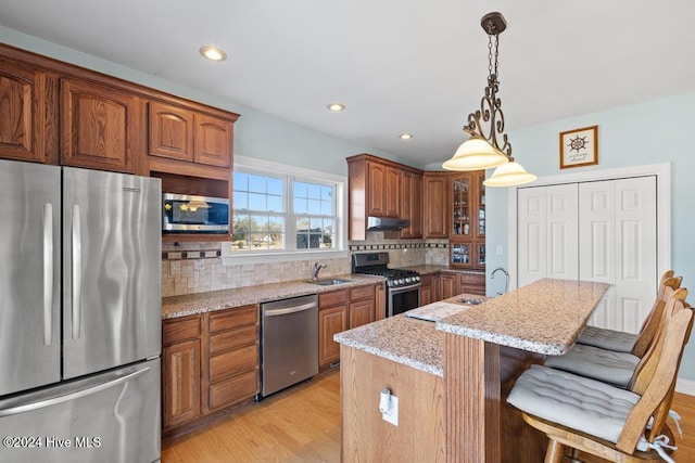 kitchen featuring decorative backsplash, appliances with stainless steel finishes, a center island, and a breakfast bar area