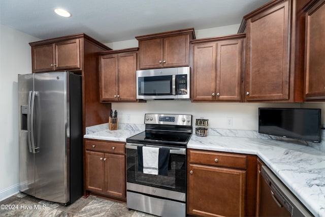 kitchen with light stone countertops and appliances with stainless steel finishes