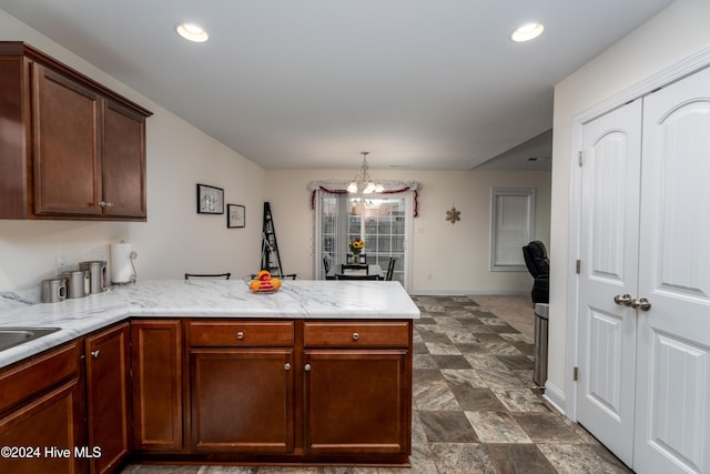 kitchen with kitchen peninsula, hanging light fixtures, and a notable chandelier