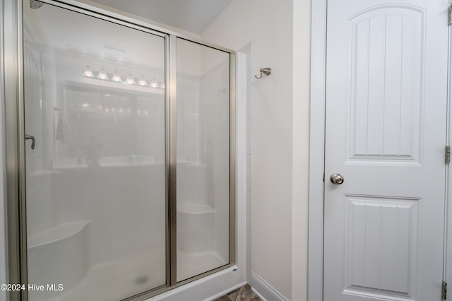 bathroom featuring a shower with shower door