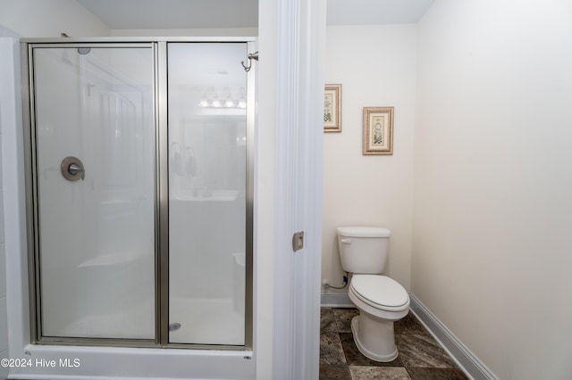 bathroom with toilet and a shower with shower door