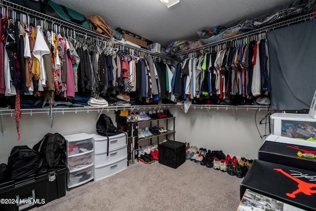 walk in closet with carpet