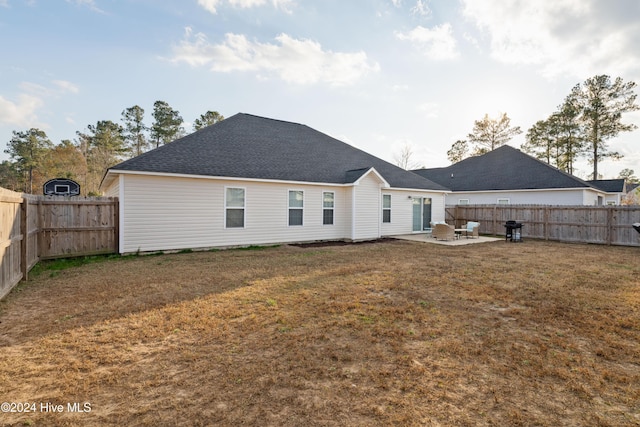 rear view of house with a patio area and a lawn