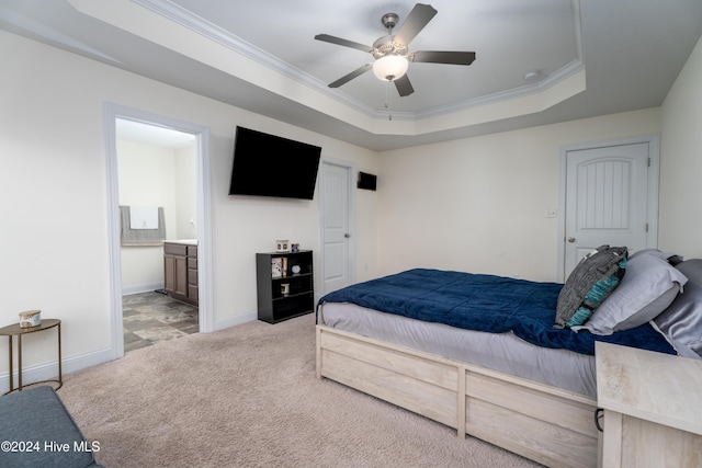 carpeted bedroom featuring connected bathroom, a tray ceiling, ceiling fan, and ornamental molding