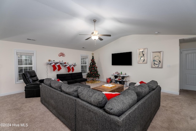 carpeted living room with ceiling fan and vaulted ceiling