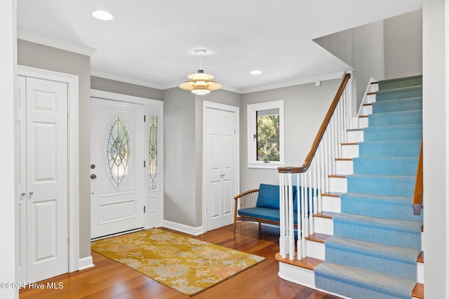 foyer entrance featuring ornamental molding and hardwood / wood-style flooring