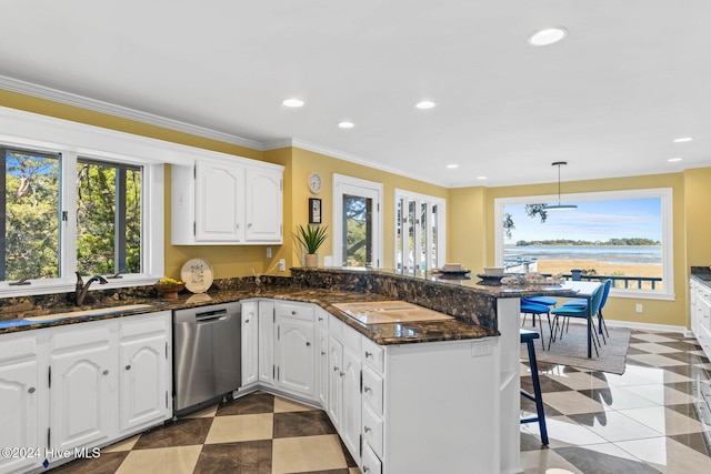 kitchen with kitchen peninsula, stainless steel dishwasher, hanging light fixtures, white cabinetry, and plenty of natural light