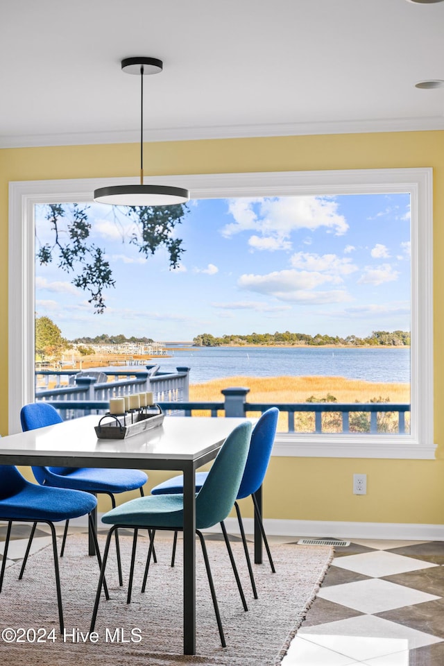 dining area with a water view and ornamental molding