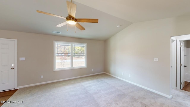 carpeted empty room featuring ceiling fan and lofted ceiling