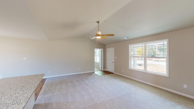 unfurnished living room featuring ceiling fan, light carpet, and vaulted ceiling