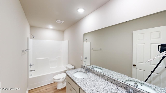 full bathroom with hardwood / wood-style floors, vanity,  shower combination, and toilet