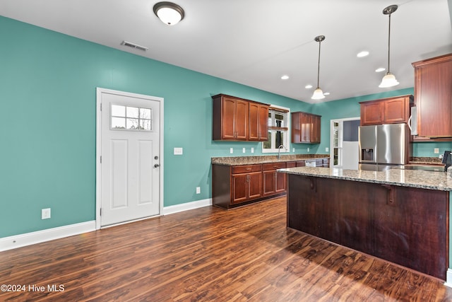 kitchen with stainless steel refrigerator with ice dispenser, light stone counters, sink, dark hardwood / wood-style floors, and hanging light fixtures