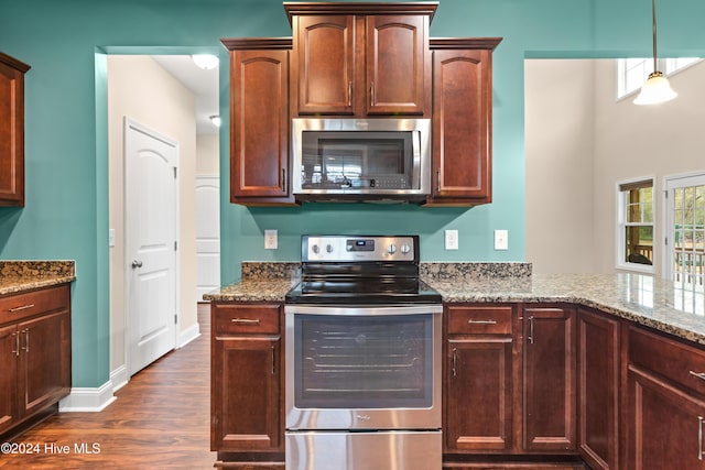 kitchen featuring light stone countertops, appliances with stainless steel finishes, dark hardwood / wood-style floors, and pendant lighting