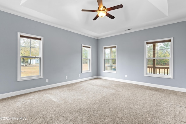 carpeted spare room with crown molding, ceiling fan, and a healthy amount of sunlight