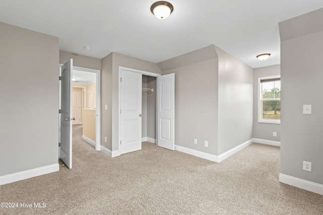 unfurnished bedroom featuring carpet flooring and a closet