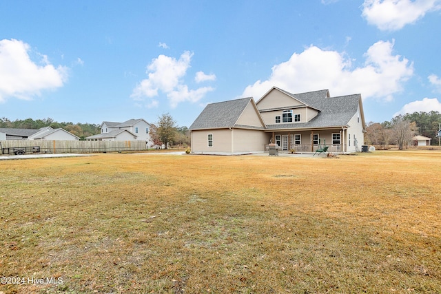 back of property with a lawn and a patio area