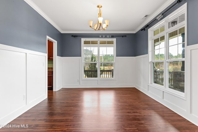 unfurnished dining area with a barn door, crown molding, dark wood-type flooring, and a notable chandelier