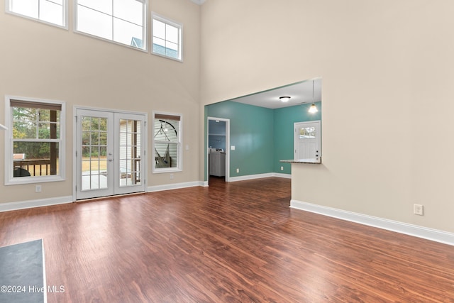 interior space featuring french doors, a towering ceiling, and dark hardwood / wood-style floors