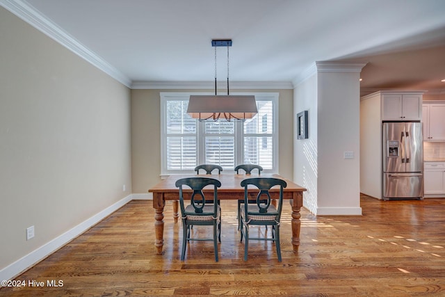 dining space featuring ornamental molding and hardwood / wood-style flooring