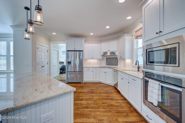 kitchen with sink, white cabinetry, stainless steel appliances, and a wealth of natural light