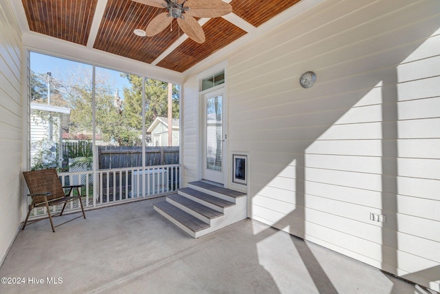 sunroom / solarium with ceiling fan, wooden ceiling, and a wealth of natural light