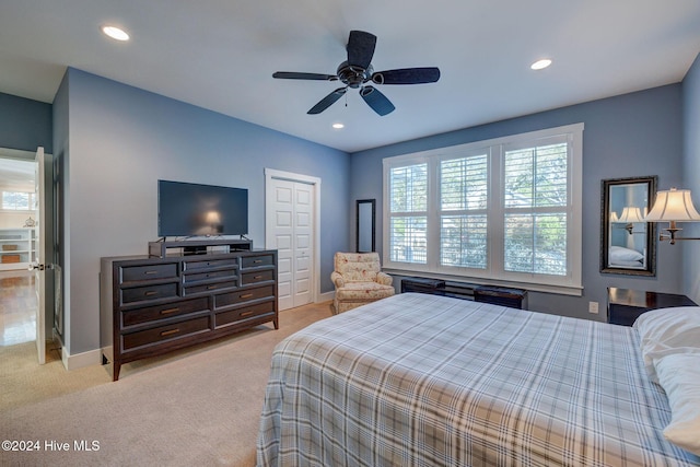 bedroom featuring ceiling fan, a closet, and light carpet