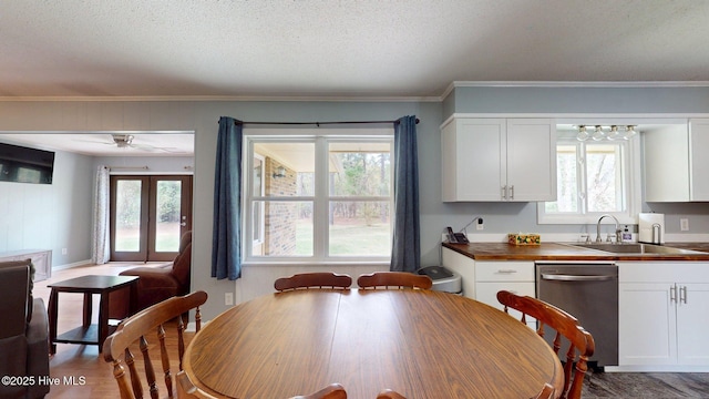 dining space featuring crown molding, a ceiling fan, wood finished floors, and a textured ceiling