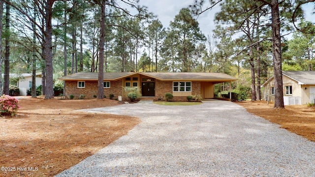 ranch-style house featuring a carport and driveway