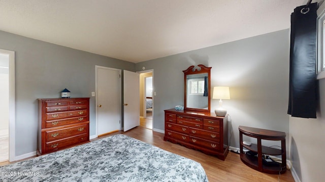bedroom featuring wood finished floors and baseboards