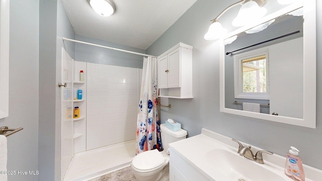 full bathroom featuring vanity, a stall shower, and toilet