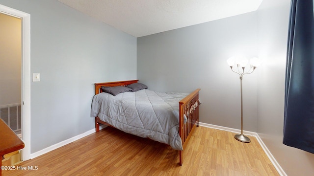 bedroom featuring visible vents, baseboards, and wood finished floors