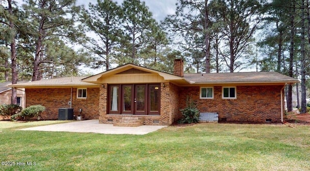 back of property featuring brick siding, a patio area, and a lawn
