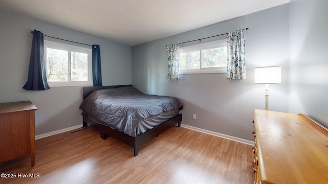 bedroom featuring baseboards and wood finished floors