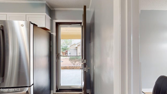 entryway featuring crown molding and a textured ceiling