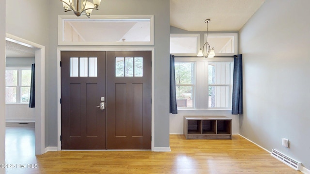 entryway featuring visible vents, baseboards, an inviting chandelier, and wood finished floors
