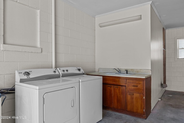 clothes washing area with washing machine and dryer, sink, cabinets, and ornamental molding