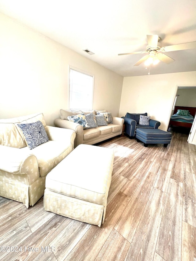 living room featuring ceiling fan and light hardwood / wood-style floors