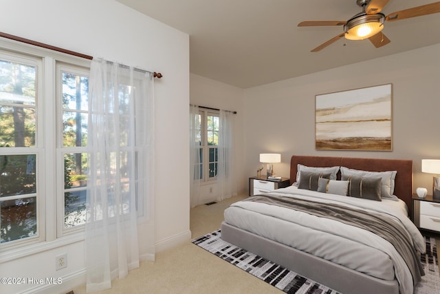 bedroom featuring ceiling fan and light carpet