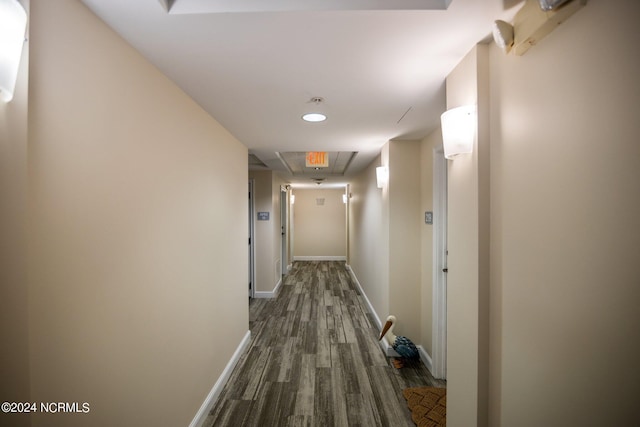 hall with dark wood-style floors, attic access, and baseboards