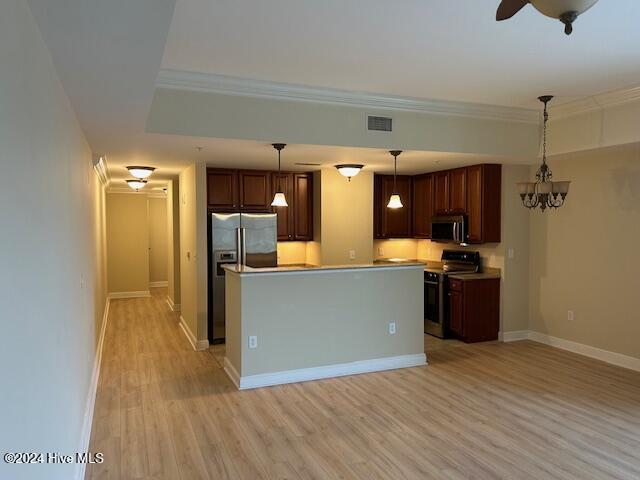 kitchen with visible vents, appliances with stainless steel finishes, a center island, hanging light fixtures, and light countertops