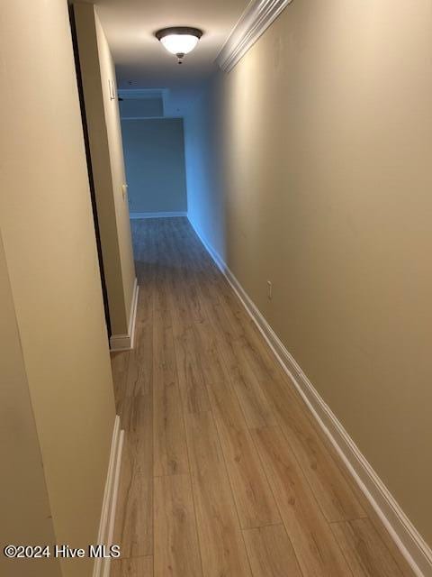 hallway featuring light wood-style floors and baseboards