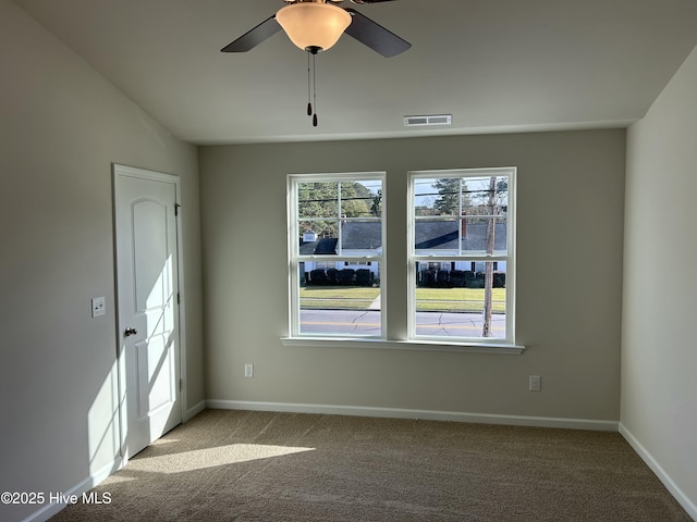 unfurnished room featuring light carpet, baseboards, visible vents, a ceiling fan, and vaulted ceiling