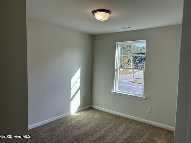 carpeted empty room with visible vents and baseboards