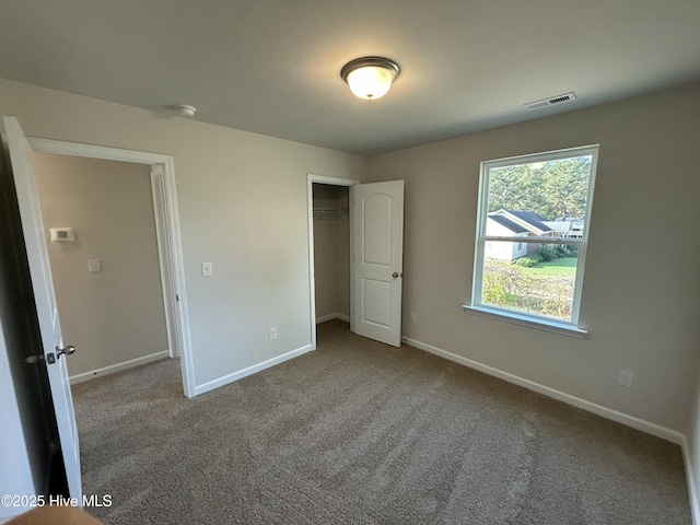 unfurnished bedroom with carpet floors, baseboards, visible vents, and a closet