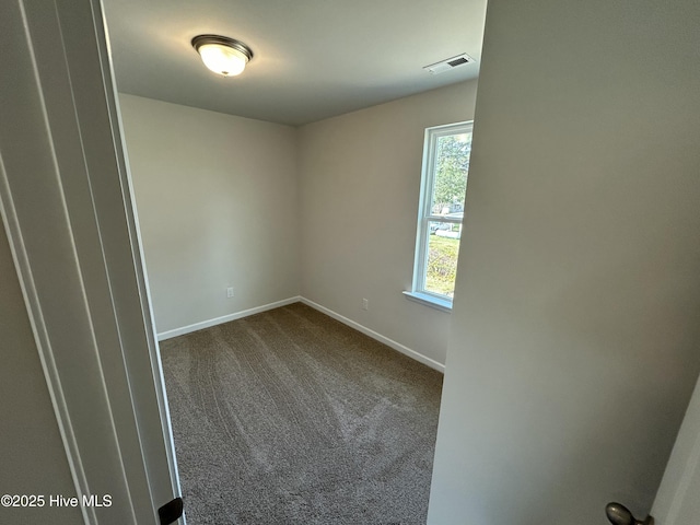 carpeted empty room with visible vents and baseboards