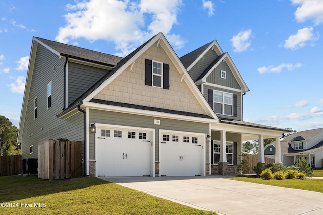 craftsman-style home featuring covered porch, a garage, and a front yard